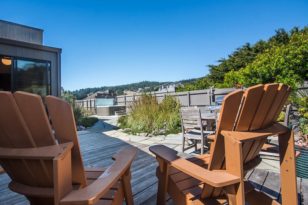 A hot tub built into a wooden deck with an ocean view